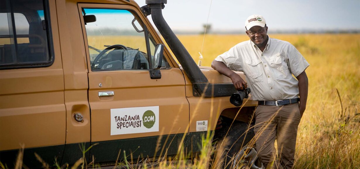 Person an Tanzania Specialist Jeep im Gras
