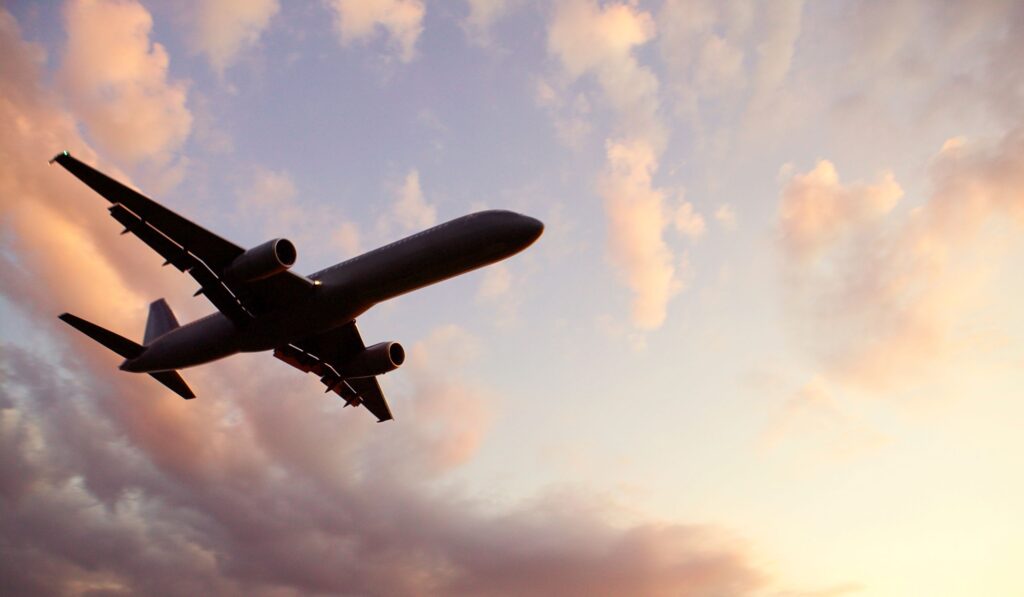 Flugzeug von unten mit Wolken im Hintergrund